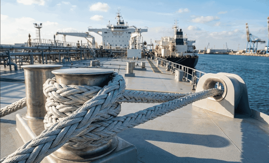 Duracordix - Il tuo fornitore di fiducia per cime e reti sintetiche ad alte prestazioni | Cos'è una cima d'ormeggio? Guida nautica completa! una cima di ormeggio marina sintetica DURACORDIX intrecciata grigia ad alte prestazioni (probabilmente in UHMWPE o fibra rivestita in DMX) fissata attorno a una bitta metallica e che passa attraverso un passacavo