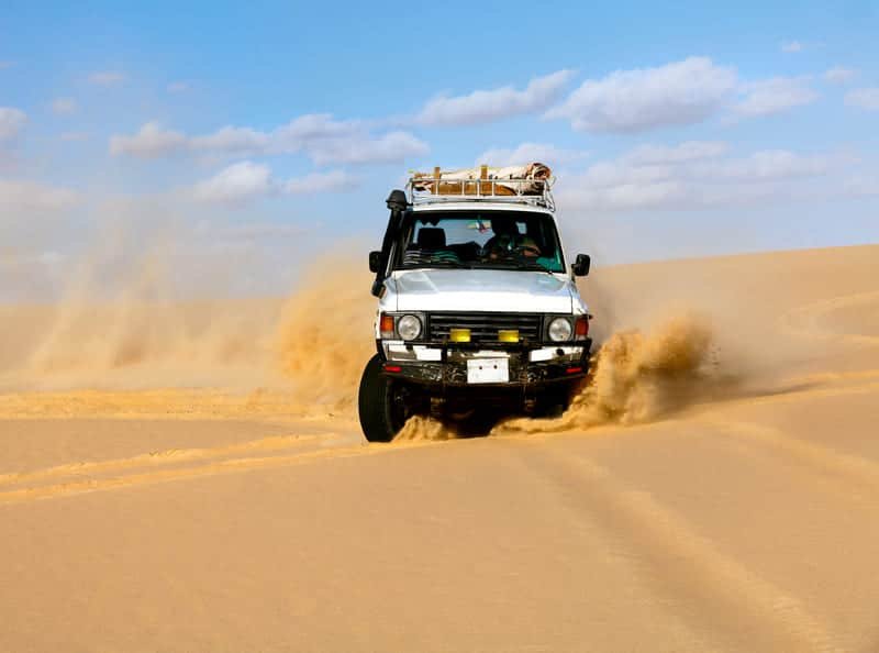 Escena de rescate en la arena con un vehículo todoterreno moviéndose a través de dunas del desierto, lo que demuestra la necesidad de un sistema de rescate Duracordix, cuerda sintética y equipo de rescate todoterreno.