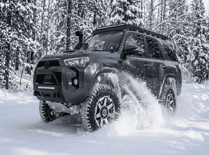 Escena de rescate en la nieve con un vehículo 4x4 avanzando a través de nieve profunda, lo que demuestra la necesidad de un sistema de rescate Duracordix, cuerda sintética y equipo de rescate todoterreno.